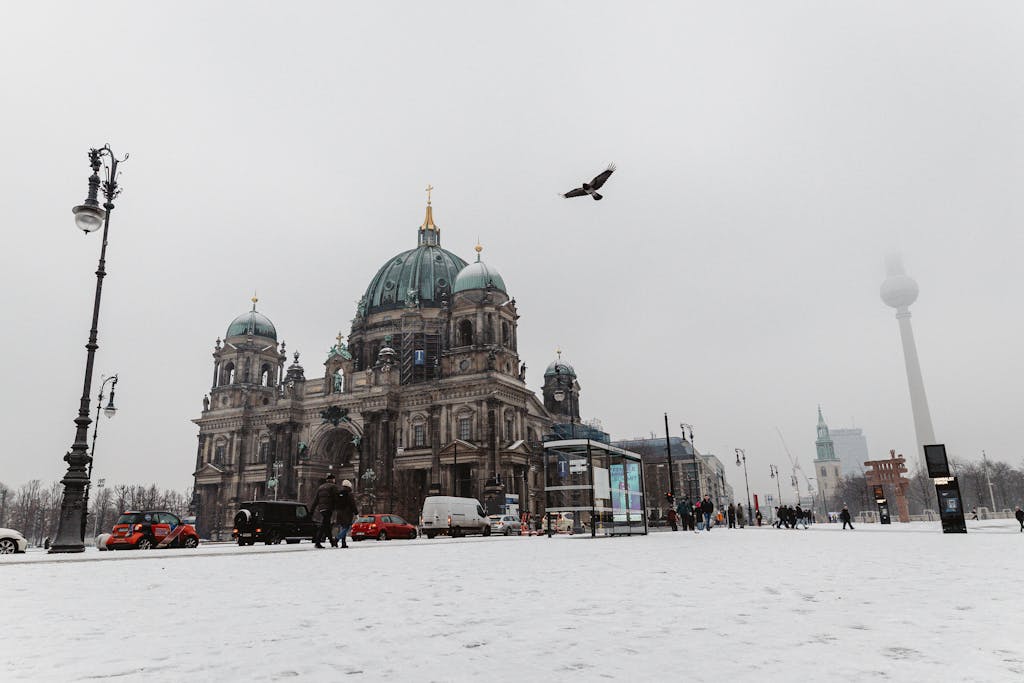 A snowy day at Berlin Cathedral with snowy streets and a soaring bird in Berlin, Germany.