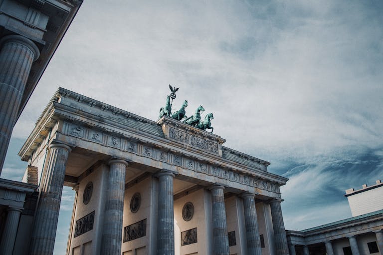 Iconic Brandenburg Gate in Berlin showcasing historical architecture against a dramatic sky.